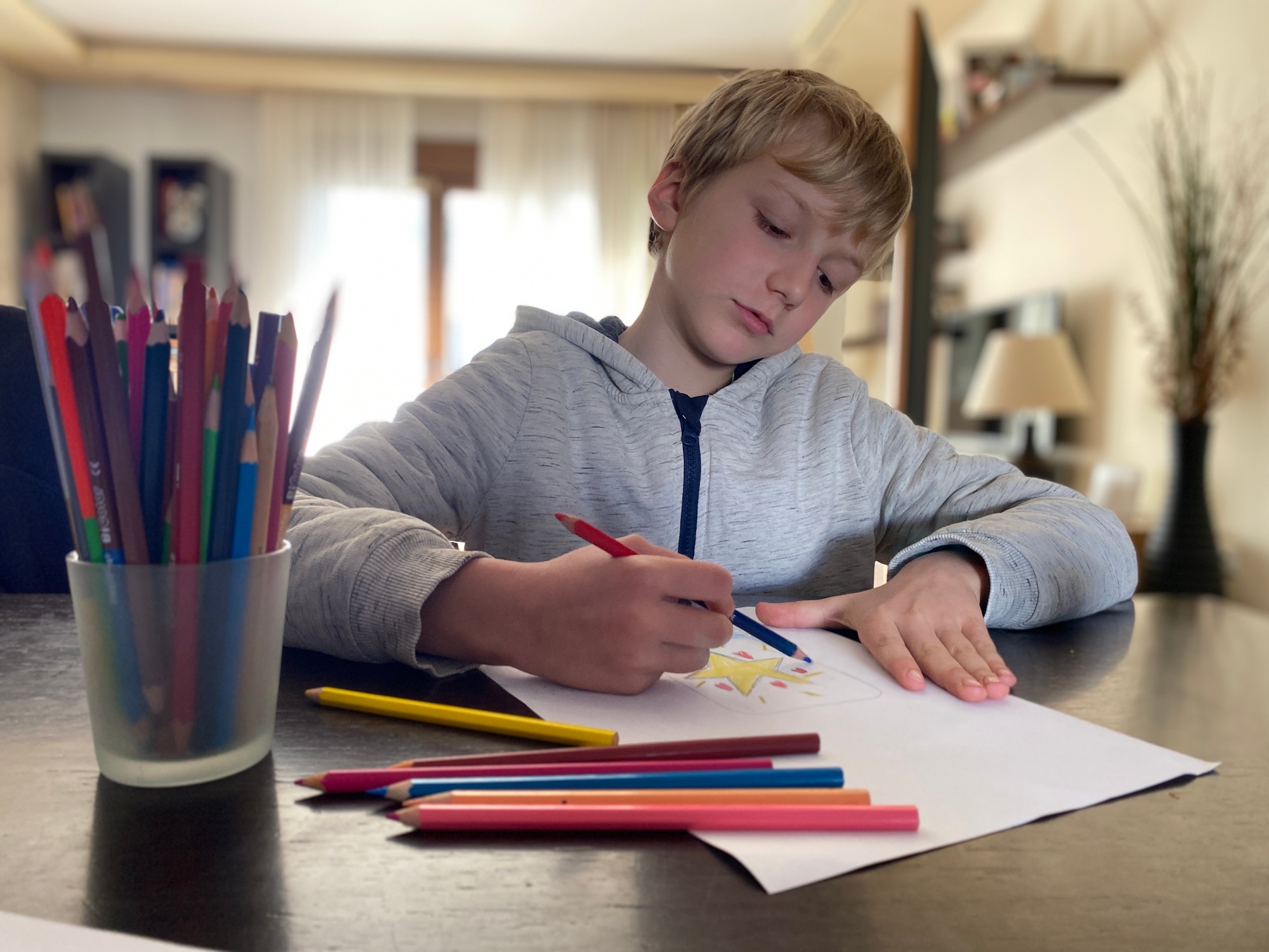Boy, 9 years old drawing with color pencils