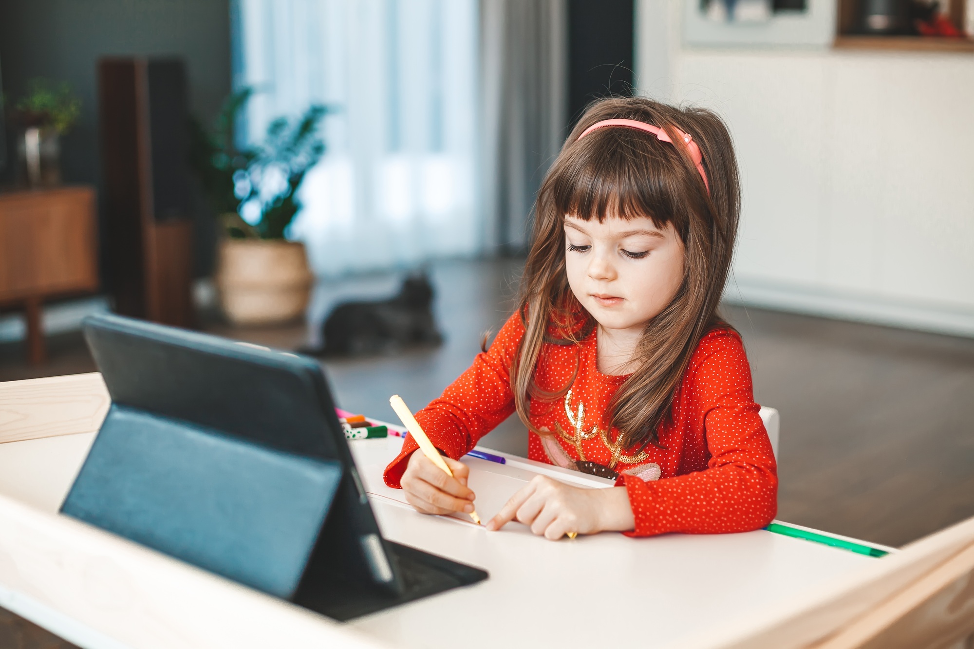 Little girl drawing on the online art lesson