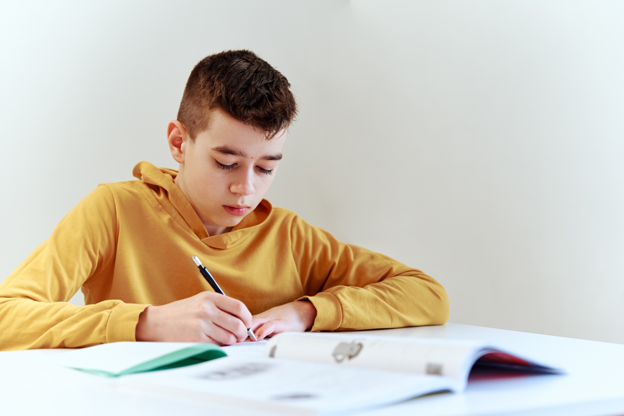 Teenage boy write homework at home. Education concept