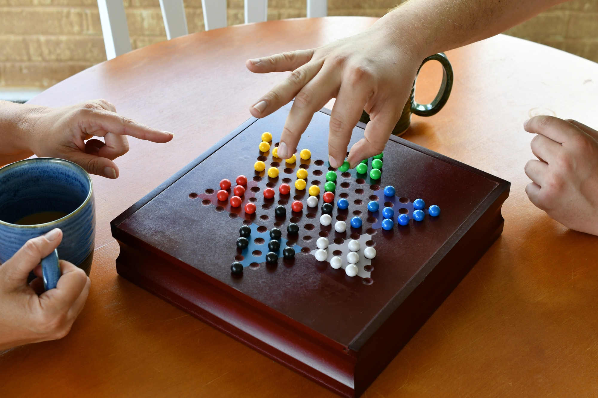 Game Night! playing Chinese checkers with colorful marbles on a wooden board.