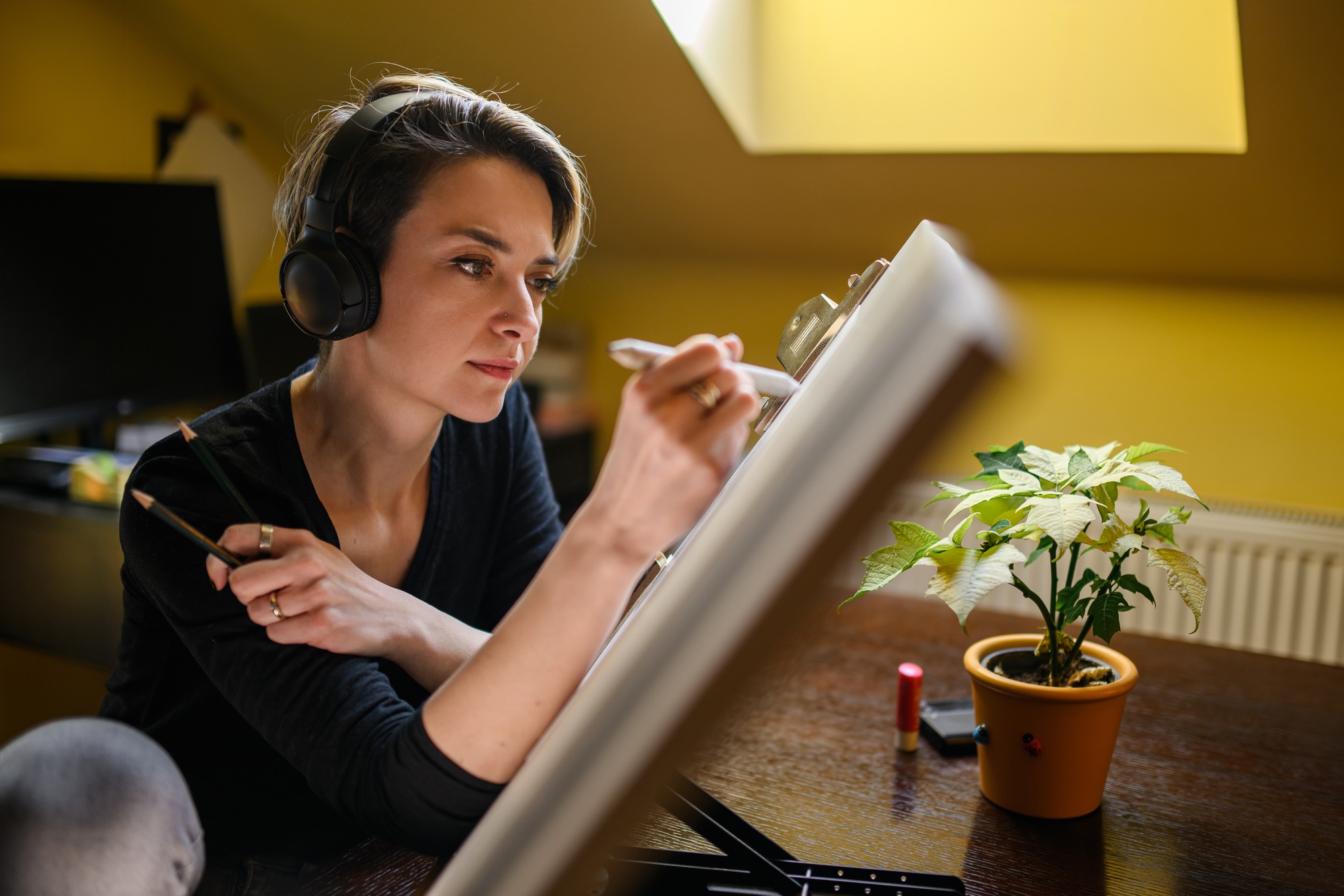 Portrait of a talented illustrator with headphones drawing sketch.