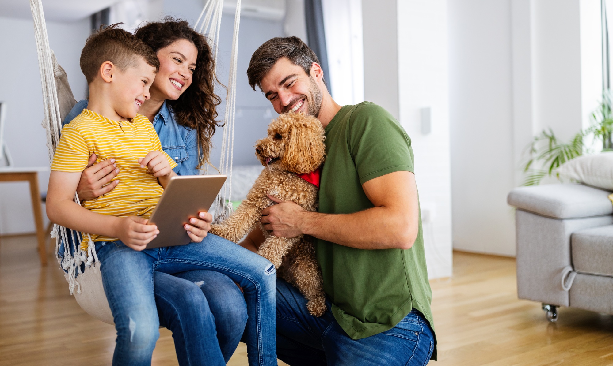 Happy family with modern devices and dog having fun, playing at home